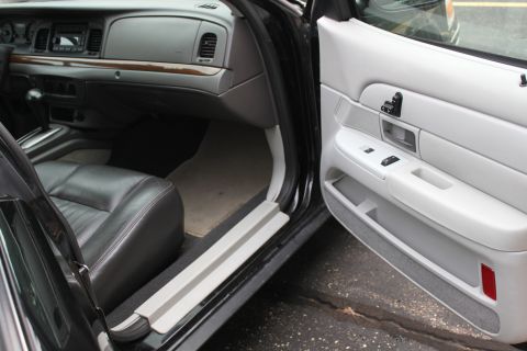 2009 Ford Crown Victoria - The interior of a 2009 Ford Crown Victoria is visible, black leather seats and a light-colored door panel.