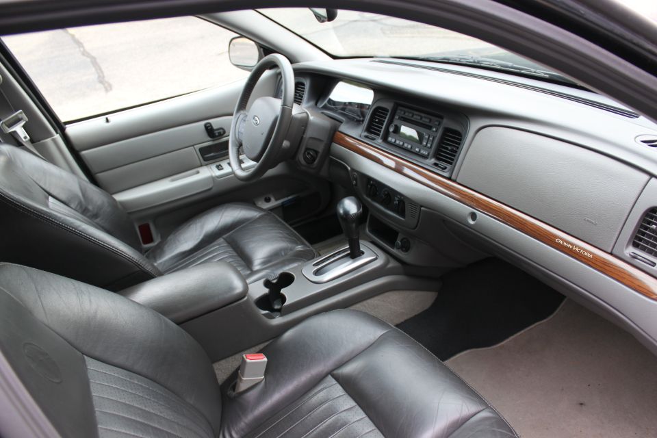 Gray leather interior of a 2009 Ford Crown Victoria, showing front seats, dashboard, and center console