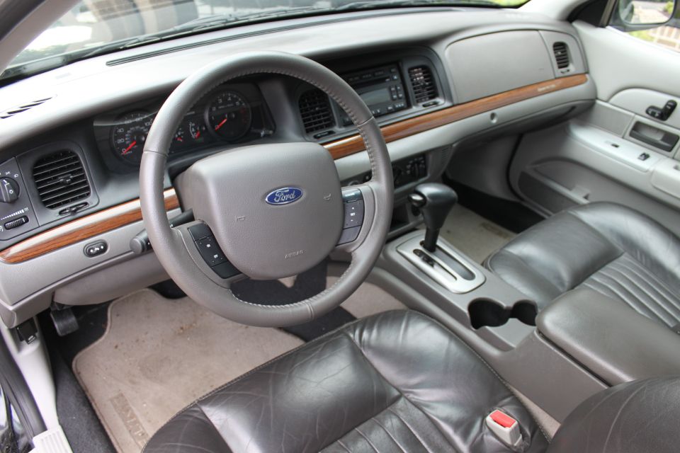 2009 Ford Crown Victoria interior showing dashboard, steering wheel with Ford logo, automatic shifter, and leather seats