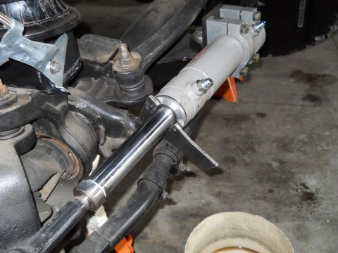 1992 Ford Bronco - Close-up view of a power steering cylinder attached to the vehicle's suspension system.