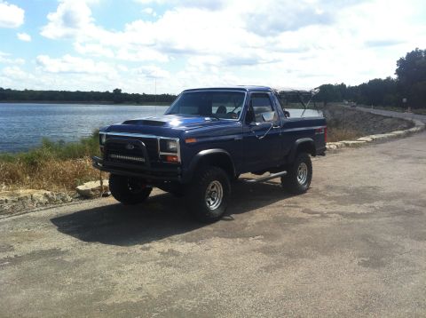 1982 Ford Bronco - This 1982 Ford Bronco is parked next to a lake on a sunny day.