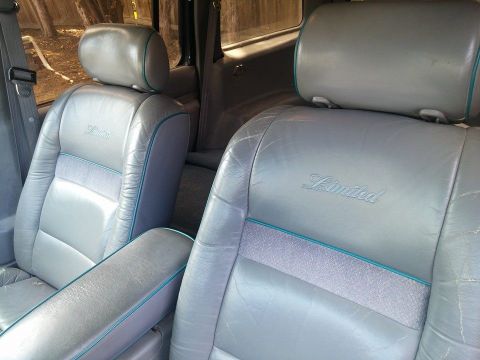 2000 Mercury Grand Marquis - The interior of the vehicle features leather seats with 'Limited' badging and teal trim.