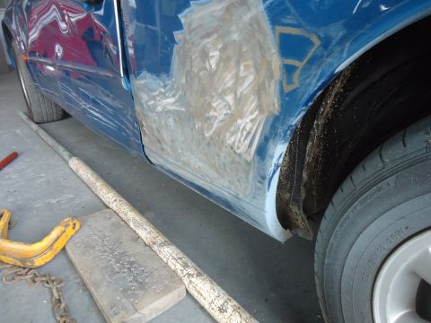 1994 Ford Thunderbird - This blue car door shows extensive body filler and repair work, indicating accident damage.