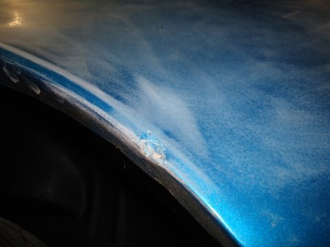 1994 Ford Thunderbird - Damage to the fender of a blue car, likely requiring repair.