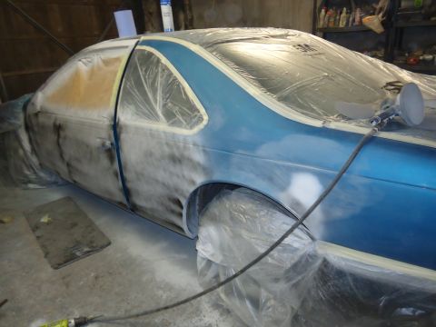 1994 Ford Thunderbird - A blue 1994 Ford Thunderbird coupe is being prepped for paint, with plastic sheeting and masking tape covering most of its body.