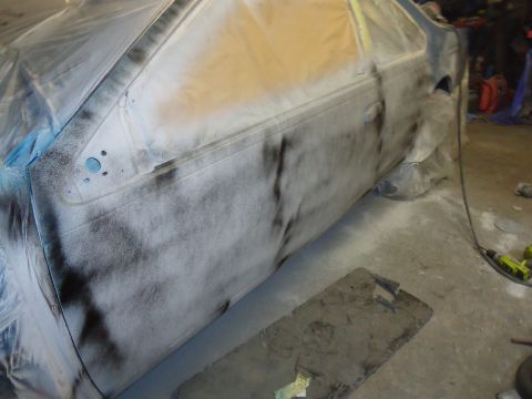 1994 Ford Thunderbird - A car door is being prepped for painting, covered in primer and masking tape, indicating accident repairs or a repaint.