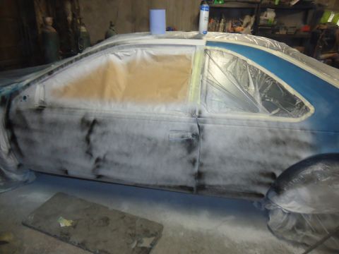 1994 Ford Thunderbird - Car bodywork covered in masking and primer spray, ready for paint application.