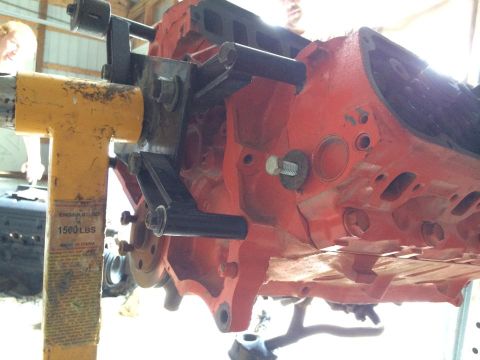 1994 Ford Bronco - A red engine block is mounted on a yellow engine stand, ready for rebuild.