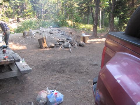 1992 Ford F-150 - Campsite scene with picnic table, campfire pit, and part of a red truck bed visible.