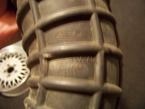 1995 Mercury Grand Marquis - A close-up shows a Ford branded air intake hose with visible part numbers and markings.