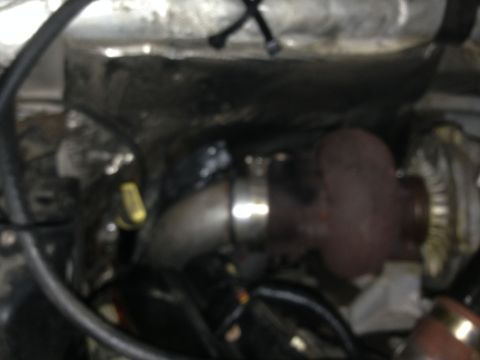 1988 Ford Bronco - Close-up view of a turbocharger and associated engine parts in a vehicle's engine bay.