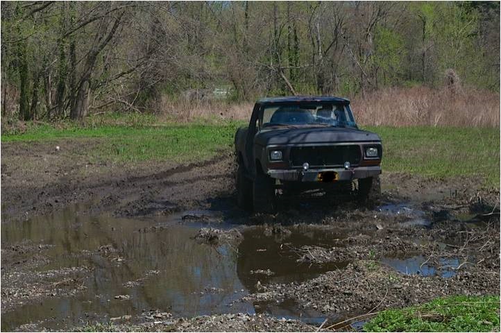 Ford F-Series truck stuck in mud, front view. Looks like a 1979 model