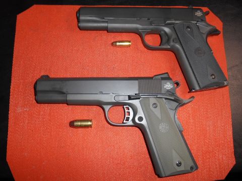 1994 Ford Bronco - Two semi-automatic pistols are displayed on a textured orange mat with ammunition.