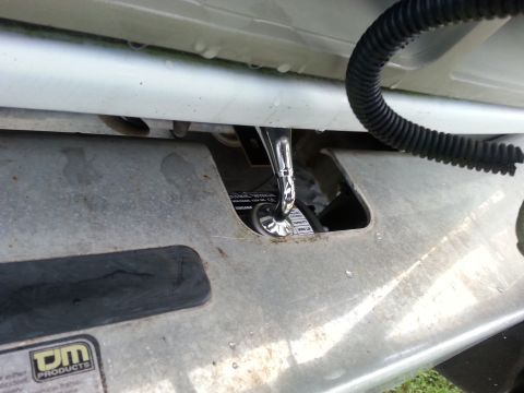 1992 Ford Bronco - A close-up shows a socket wrench being used to secure winch mounting hardware on a vehicle's frame.