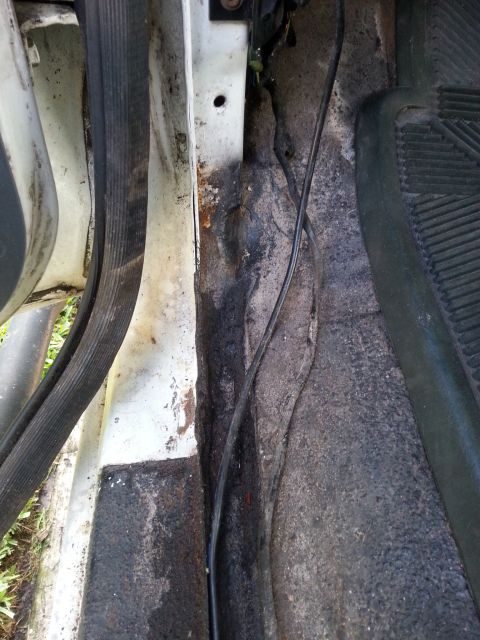 1992 Ford Bronco - Close-up of a vehicle's interior door sill showing signs of wear and potential water damage.