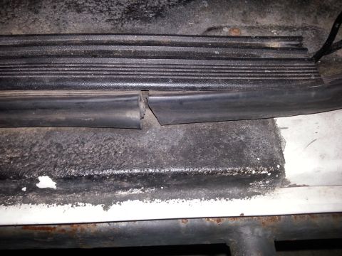 1992 Ford Bronco - Close-up of a damaged door threshold seal, indicating a potential leak point.