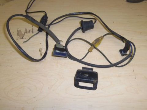 1979 Ford F-150 - A close-up view of a vehicle wiring harness and a mounting bracket, laid out on a wooden surface.