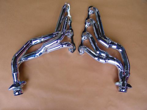 1982 Ford Bronco - Chrome exhaust headers shown against a brown background. Text at the bottom reads SUPERMOTORS.