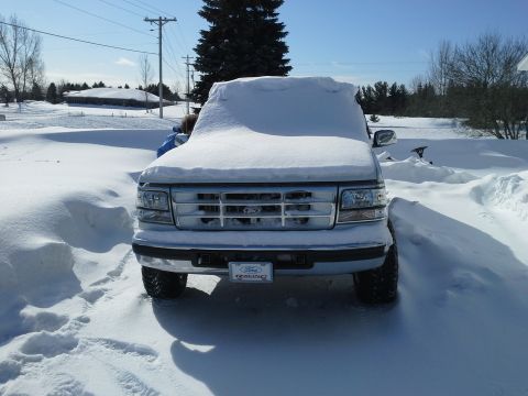 1996 Ford Bronco - A Ford truck is parked in a snowy area, with snow covering most of its body.