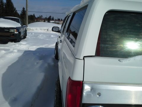 1996 Ford Bronco - 1996 Ford Bronco seen parked in a snowy area next to another truck.