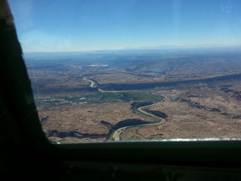 2005 Jeep Wrangler - View from a window shows a vast desert landscape with a river snaking through it and a small town in the distance.