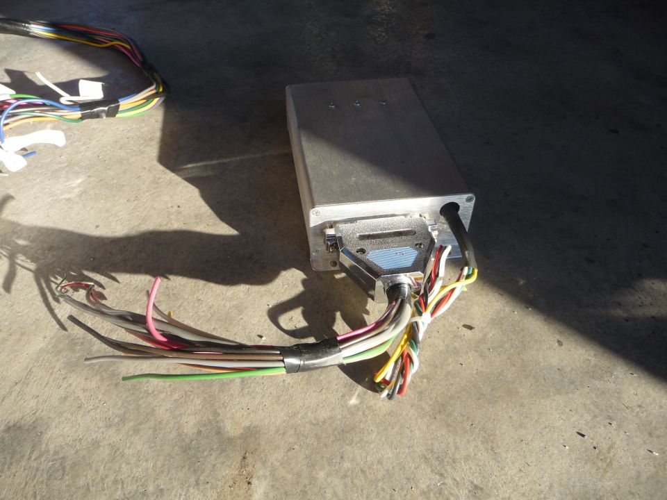 Aluminum electronic control unit with a large multi-pin connector and a bundle of multicolored wires attached