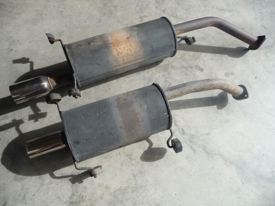 Two used exhaust mufflers with chrome tips and bent pipes