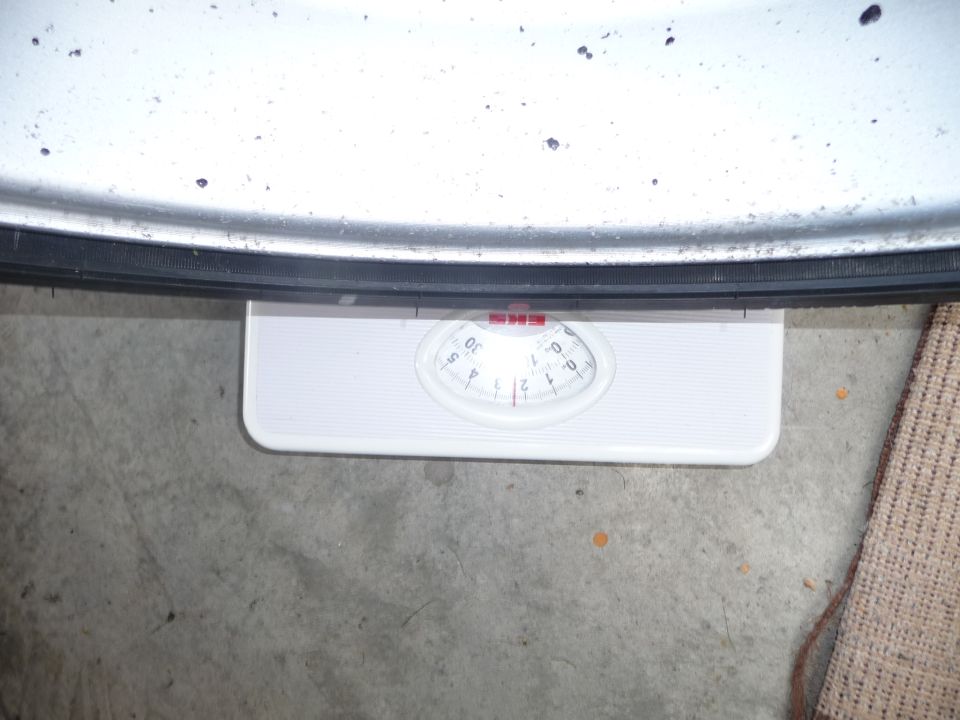 Close-up of a tire resting on a white bathroom scale