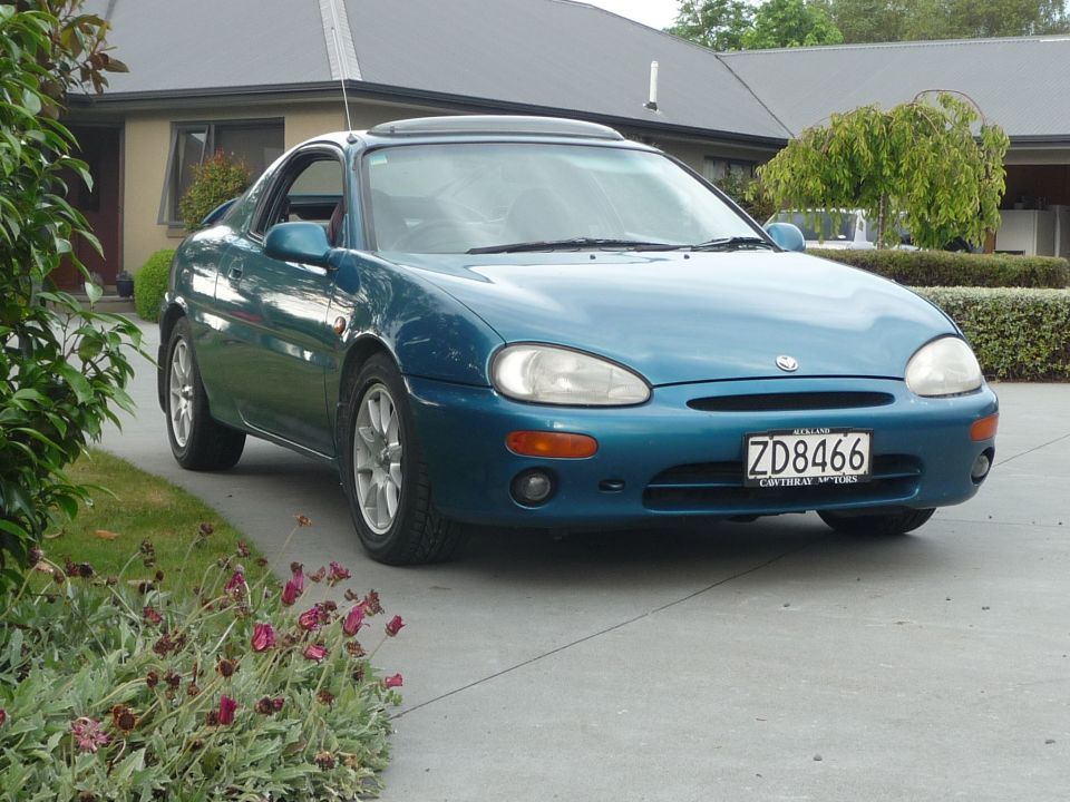 Teal 1993 Mazda MX-3 parked in driveway
