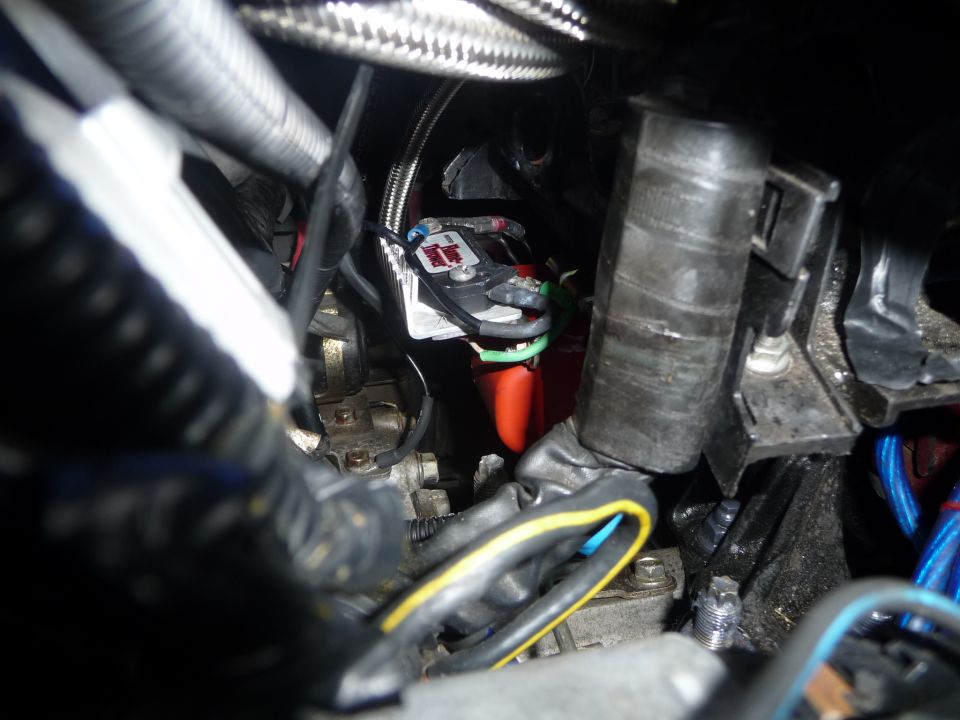 Close-up of engine bay wiring, including a fuse box and various cables