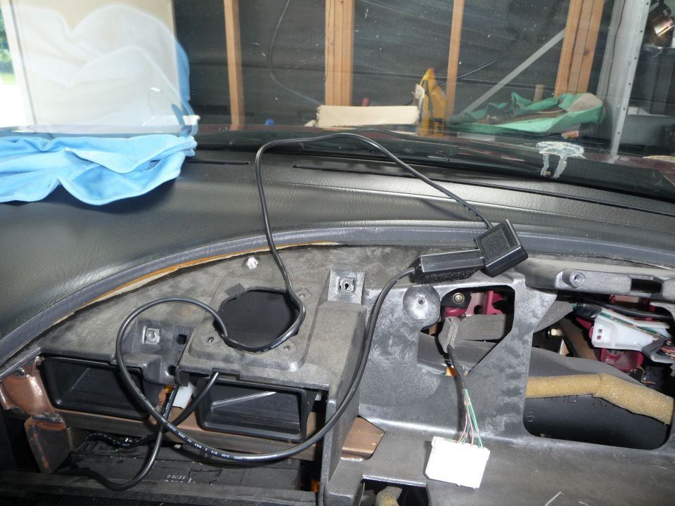 Car dashboard with wires and vents exposed, blue cloth on dash