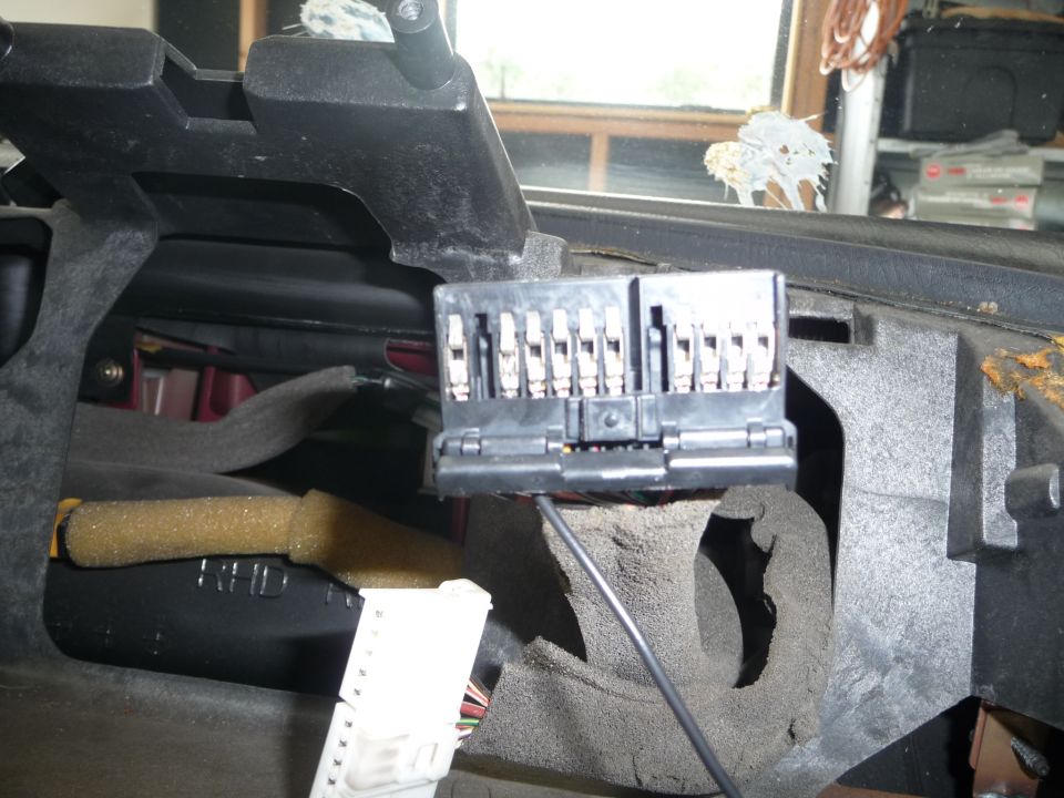 Close-up of a car's interior fuse box with multiple connectors