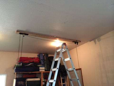 1989 Ford Bronco - A DIY garage ceiling hoist system is shown with a ladder and storage shelves in the background.
