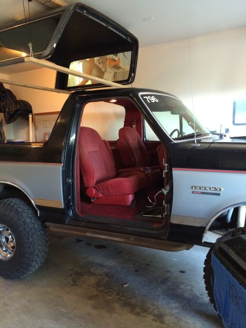 1989 Ford Bronco - The removable roof section of a 1989 Ford Bronco is suspended above the vehicle's interior.