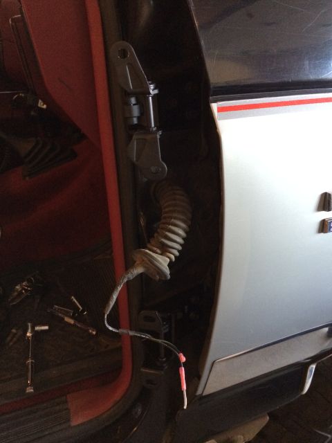 1989 Ford Bronco - Close-up view of a vehicle's door hinge and wiring harness, showing interior details.