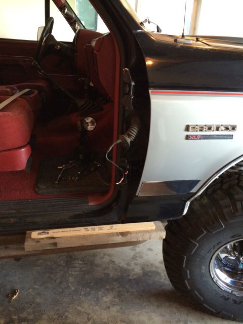 1989 Ford Bronco - Interior view of a 1989 Ford Bronco, showing red upholstery and the exterior side panel with the model name badge.