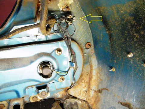 1968 Mercury Cougar - Detail of the inner fender well showing wiring and a headlight mounting point, with a yellow arrow pointing to a switch.