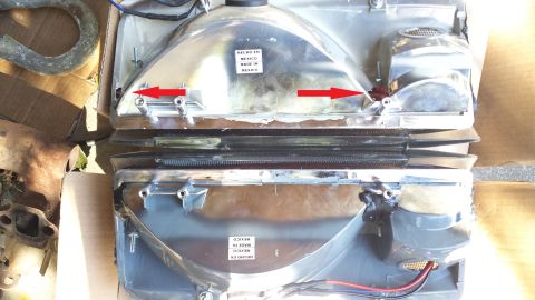 1992 Ford Bronco - Close-up view of two vehicle headlights, with red arrows indicating mounting locations.