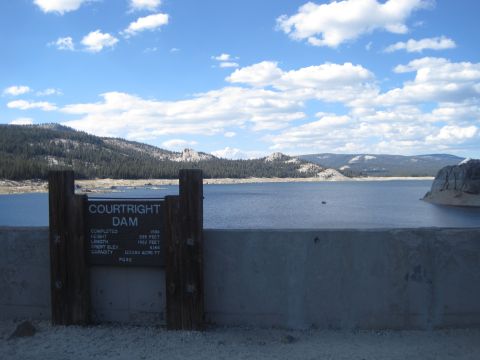 1989 Ford Bronco - A sign detailing the specifications of Courtright Dam stands before a wide reservoir under a partly cloudy sky.