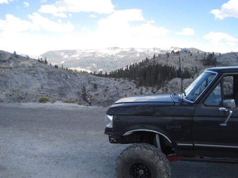 1989 Ford Bronco - 1989 Ford Bronco parked on a gravel road with snow-capped mountains in the distance.