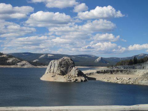 1989 Ford Bronco - A scenic view of a rocky island in a vast lake, surrounded by hills and a partly cloudy sky.