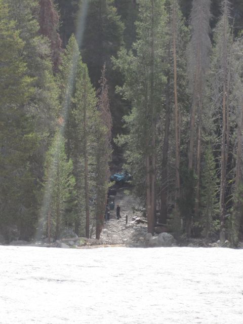 1989 Ford Bronco - Off-road vehicles are seen on a dirt path surrounded by trees and snow.