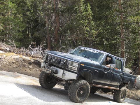 1989 Ford Bronco - This modified Ford F-Series truck is navigating a steep, unpaved mountain road.