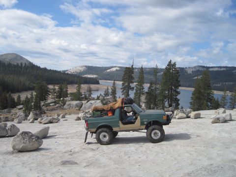 1989 Ford Bronco - 1989 Ford Bronco parked on a rocky overlook with a scenic lake and forest view.