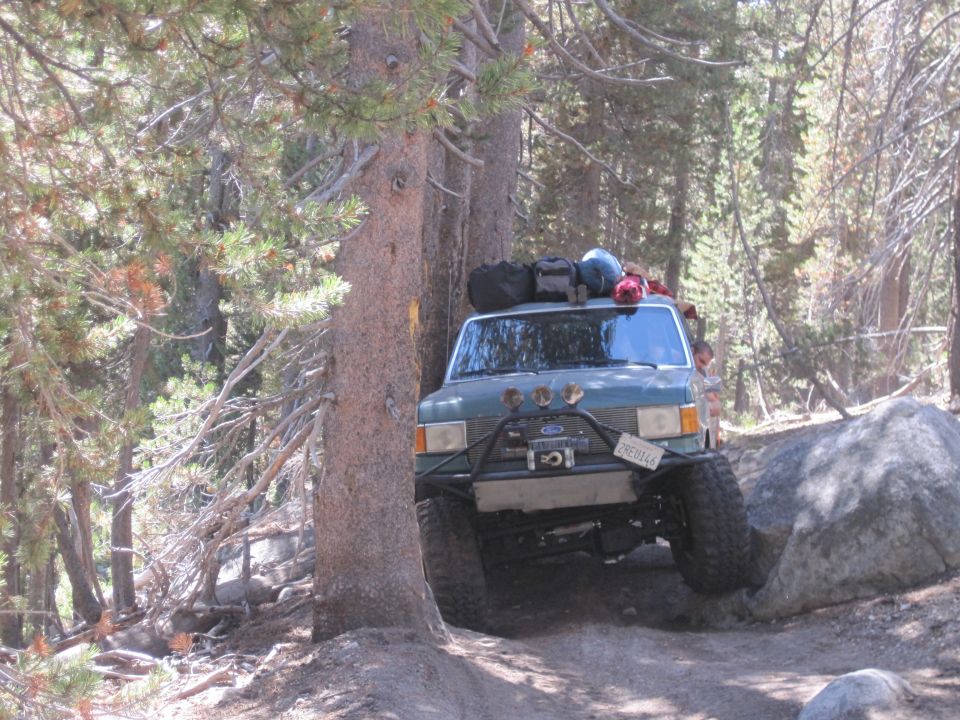 1989 Ford Bronco with off-road modifications navigating a rocky trail