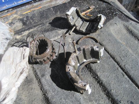 1989 Ford Bronco - Damaged transmission components, including a gear and fractured housing, lie on a textured surface.