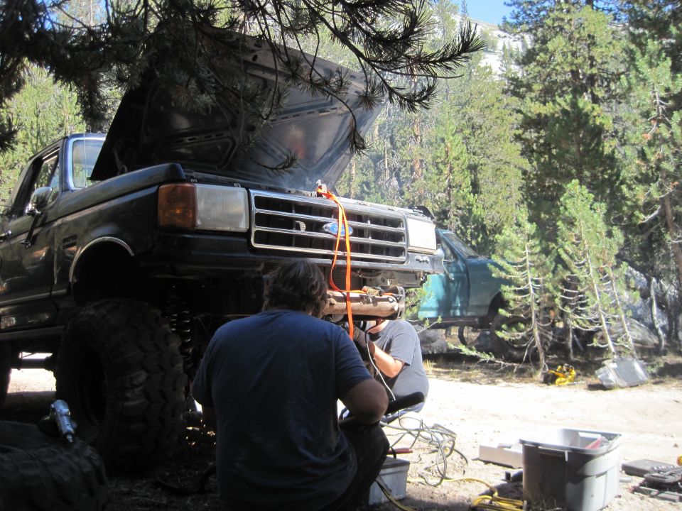 Front view of a black 1987-1991 Ford F-Series truck with hood open, being worked on outdoors