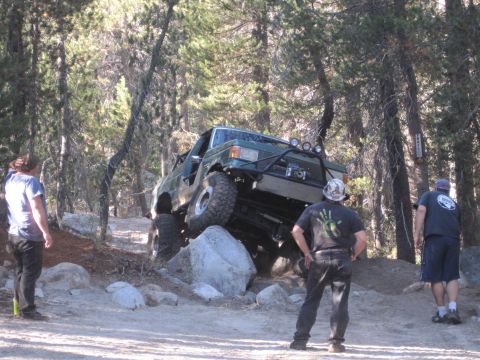 1989 Ford Bronco - Green 1989 Ford Bronco tackles a difficult rocky trail with spectators observing the action.