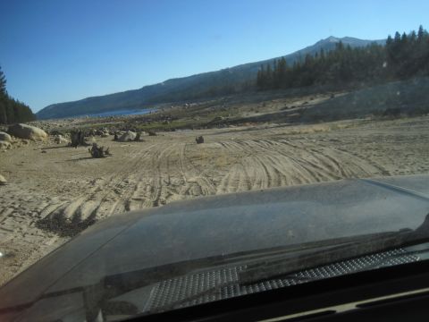 1989 Ford Bronco - Driving through a , dry terrain with a clear blue sky overhead.