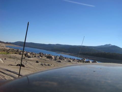 1989 Ford Bronco - View from a vehicle's roof overlooking a dry, rocky landscape leading to a blue lake under a clear sky.